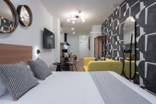 a bedroom with a bed and a living room at Smartr Valencia Turia in Valencia