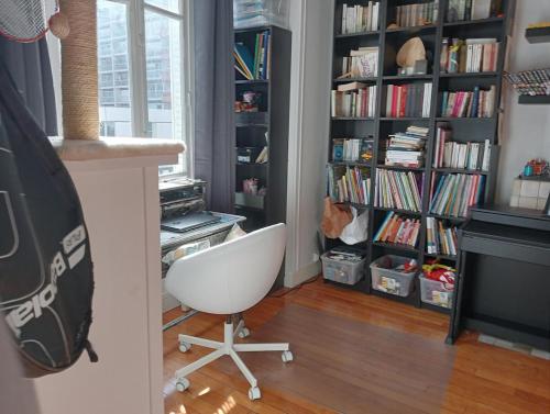 une chambre avec une chaise blanche devant une étagère dans l'établissement 2 rooms Paris 13 near Cité U, à Paris