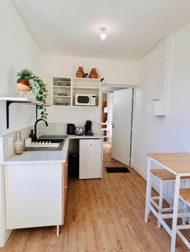 une cuisine avec des armoires blanches et un comptoir dans l'établissement Mini Studio Tout confort - accès facile Nantes et Vendée, à Pont-Saint-Martin