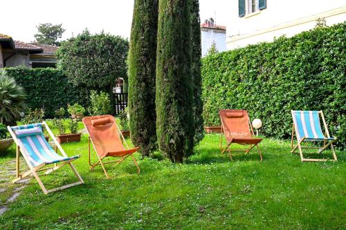 three chairs sitting in the grass in a yard at Il Villino di Monic Pisa centro in Pisa