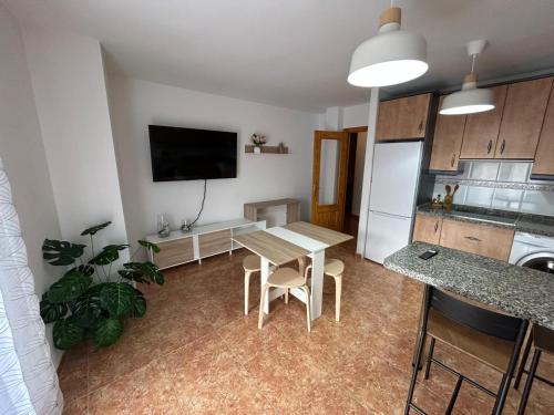 Una cocina y un comedor con una mesa y un refrigerador. en Apartamento, en Carboneras