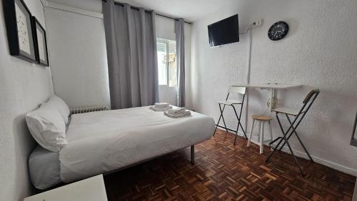 a bedroom with a bed and a table and chairs at Estudio en Gran Via centro in Madrid