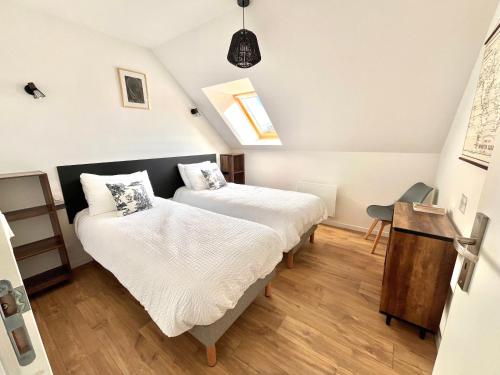 deux lits dans une petite pièce avec une fenêtre dans l'établissement Gîte Louise entre Erquy et Fréhel 2 chambres, à Plurien