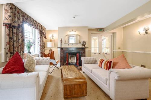 a living room with two white couches and a fireplace at La Fleur De Lys in Shaftesbury