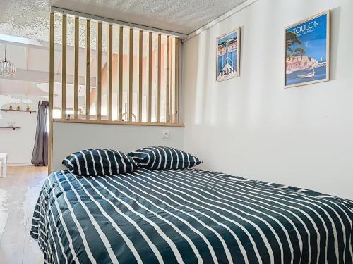 une chambre avec un lit avec deux oreillers dessus dans l'établissement Charmant cocon , proche marché, port et gare, à Toulon