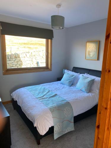 a bedroom with a large bed with a window at Apartment 1, Craigmore in Lerwick