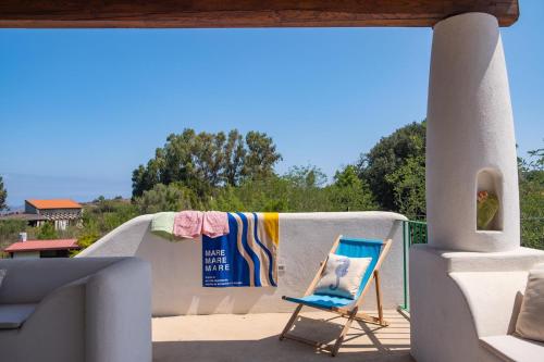 a blue chair sitting on a porch with a towel at Casa Aurelia 10 min dal Porto 5 dal Cratere in Isola Vulcano