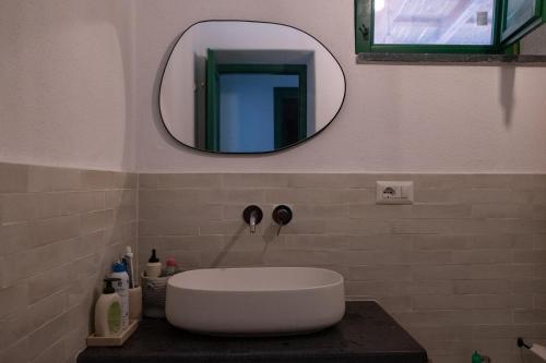 a bathroom with a white sink and a mirror at Casa Aurelia 10 min dal Porto 5 dal Cratere in Isola Vulcano