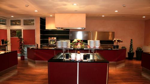 a large kitchen with a counter in a room at Parkhotel Olsberg in Olsberg