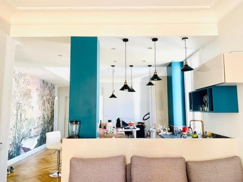 une cuisine aux murs bleus et un canapé dans une chambre dans l'établissement Spacious Appartment 5 min to sea, à Nice