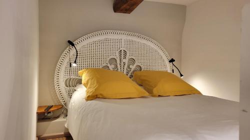 a bedroom with a white bed with yellow pillows at Bed and Breakfast Jardin de Marie in Aix-en-Provence