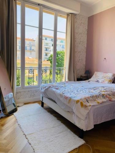 une chambre avec un lit et une grande fenêtre dans l'établissement Spacious Appartment 5 min to sea, à Nice