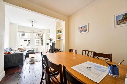 a dining room and living room with a wooden table at GuestReady - Charming family retreat in London in London