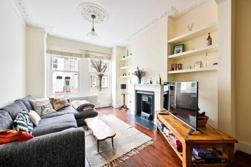 a living room with a gray couch and a fireplace at GuestReady - Charming family retreat in London in London