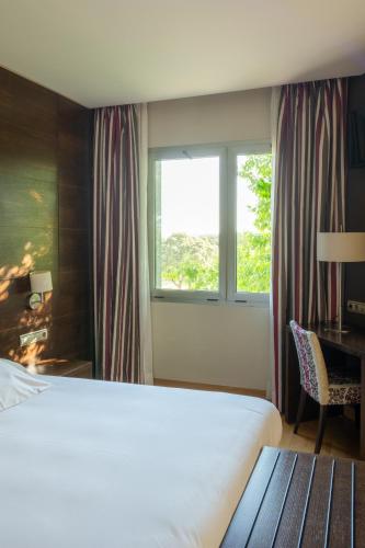 a bedroom with a large bed and a window at Hotel FC Villalba in Collado-Villalba