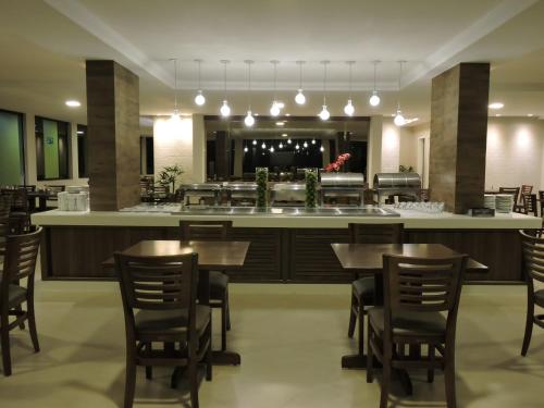 a restaurant with tables and chairs and a bar at Caruaru Park Hotel in Caruaru