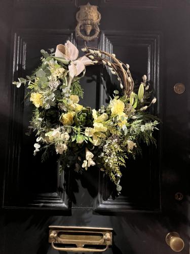 a mirror with a floral wreath on a table at The Glastonbury Townhouse B&B in Glastonbury