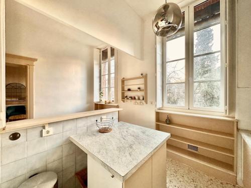 une cuisine avec un comptoir et une fenêtre dans l'établissement Grand Appartement Standing Lit King Size Capitole, à Toulouse