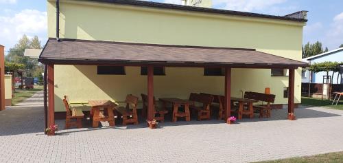 a pavilion with wooden tables and chairs on a sidewalk at Penzion Terezka in Hlučín