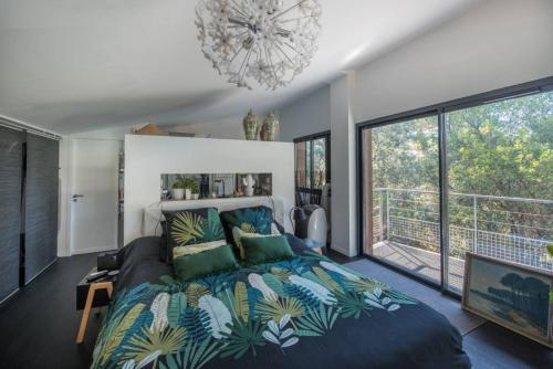 una camera da letto con un letto grande e una grande finestra di Arcachon-Moulleau Belle villa avec piscine et jardin privés a La Teste-de-Buch