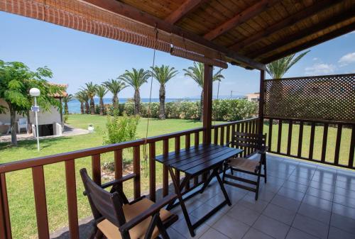 a table and chairs on a balcony with a view of the ocean at Kotsoris Studios in Kyparissia