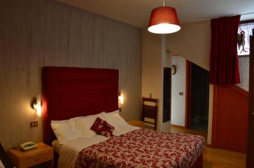 a hotel room with a bed with a red headboard at Albergo Sella - Monte Amiata in Abbadia San Salvatore