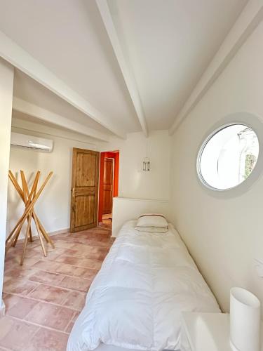 un lit dans une chambre avec une fenêtre dans l'établissement Mas rénové par un architecte, au Plan-de-la-Tour