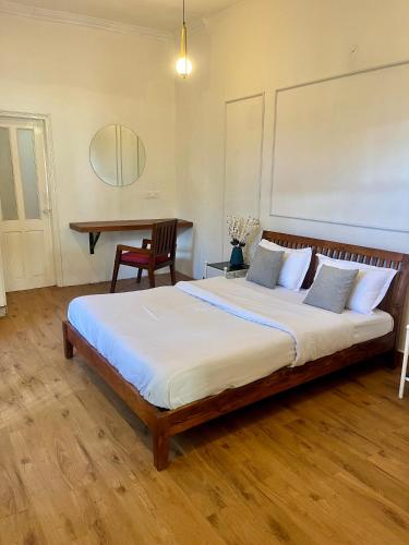 a bedroom with a large bed and a table at AruBhi Cottage in Dehradun