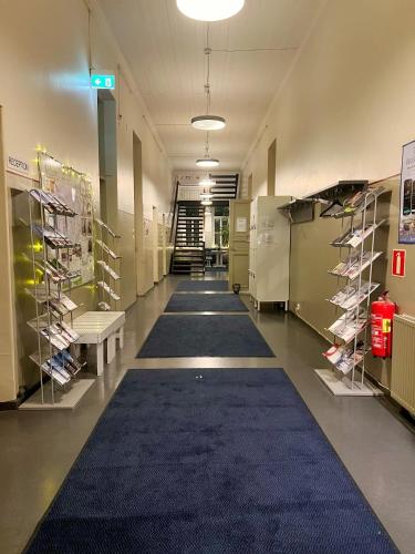 a hallway with a blue carpet in a store at Hostel Suomenlinna in Helsinki
