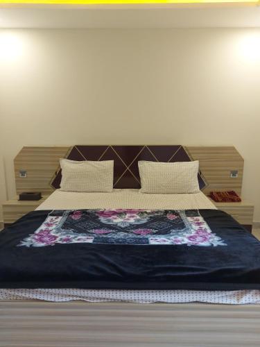 a bedroom with a large bed with a blue blanket at Farooq hotel in Swat
