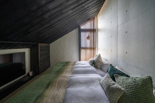 今帰仁村にあるAO NAKIJIN amahaji terraceの大きな窓のある部屋にある大きなベッド