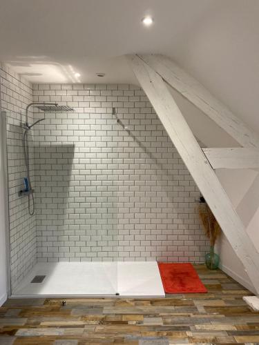 une douche mansardée avec un mur en briques blanches dans l'établissement Maison bords de Loire, Montjean sur Loire, 4 pers, à Montjean-sur-Loire