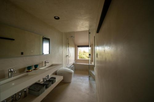 a bathroom with a sink and a toilet and a mirror at AO NAKIJIN yanbaru terrace in Nakijin