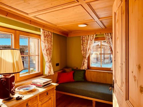 a living room with a green couch and two windows at TONIS cozy Guesthouse by Alpin Charme Apartments in Reith bei Kitzbühel