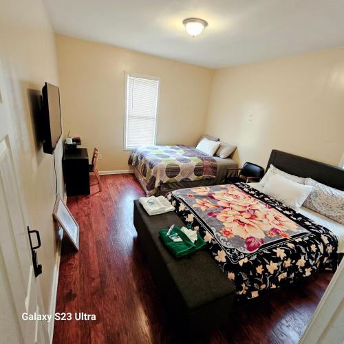 a bedroom with two beds and a couch in it at Divine Villa & Resorts Guest House - 283 Lehigh Ave in Newark
