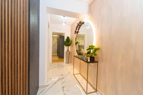 ブラショヴにあるGolden Luxury Apartmentの鏡と植物が壁に掛けられた廊下