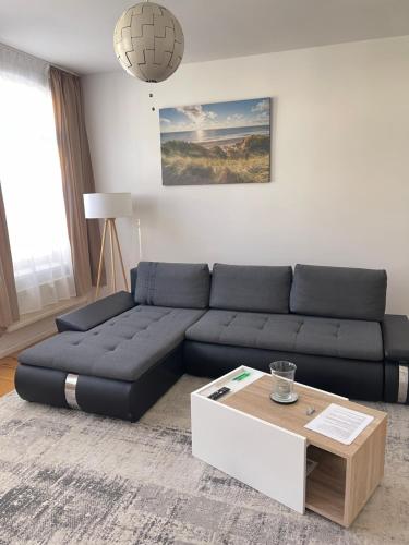 a living room with a black couch and a coffee table at FeWo Meeres Luft in Wismar