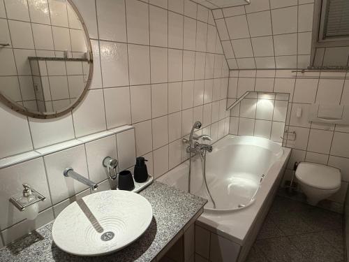 a bathroom with a sink and a toilet and a mirror at Stilvolles Apartment mit Dachterrasse in Garbsen