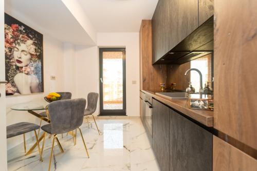 ブラショヴにあるGolden Luxury Apartmentのキッチン(シンク、テーブル、椅子付)