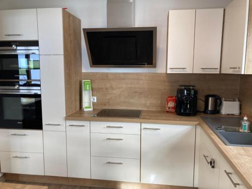 a kitchen with white cabinets and a microwave at Urlaub bei Schönwetter in Raumberg