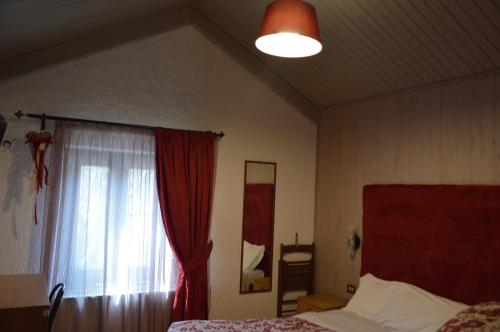 a bedroom with a bed and a window with a curtain at Albergo Sella - Monte Amiata in Abbadia San Salvatore