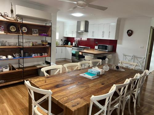 a kitchen and dining room with a wooden table and chairs at OneWorldLove Garden in Woy Woy