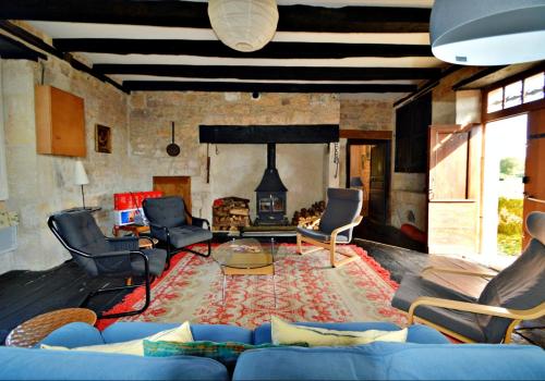 a living room with a blue couch and a fireplace at Les Maratoux in La Chapelle-Saint-Jean