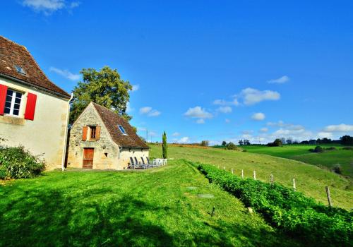 an old house on a green field with a fence at Les Maratoux in La Chapelle-Saint-Jean