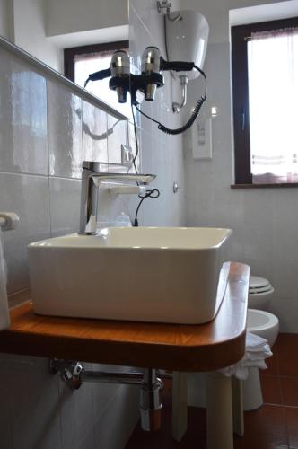 a bathroom with a sink with a light above it at Albergo Sella - Monte Amiata in Abbadia San Salvatore