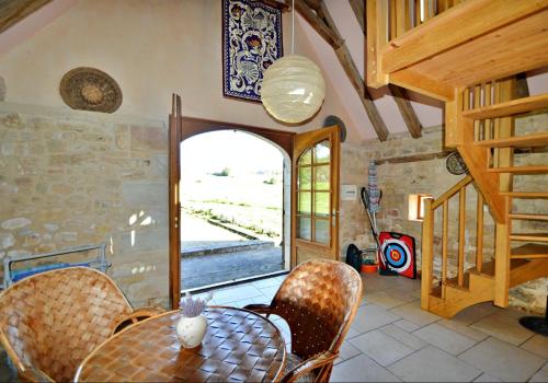a dining room with a table and chairs and a window at Les Maratoux in La Chapelle-Saint-Jean
