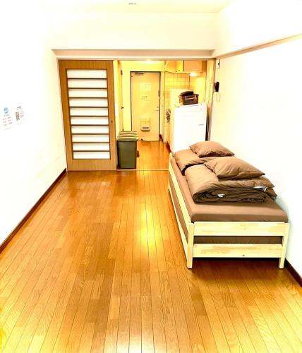 une chambre avec un lit et un parquet dans l'établissement ゲストハウスＥn プレザント203, à Orio