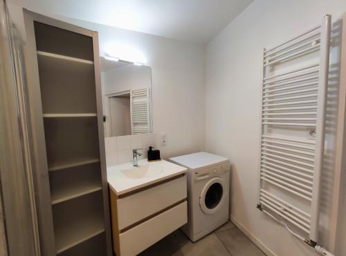 une salle de bain avec un lavabo et une machine à laver dans l'établissement L'Élégant - Focalimmo, à Foix