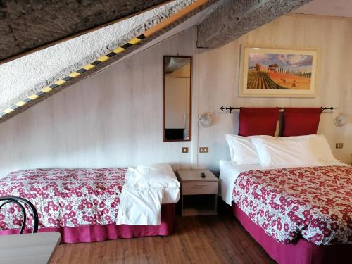 A bed or beds in a room at Albergo Sella - Monte Amiata