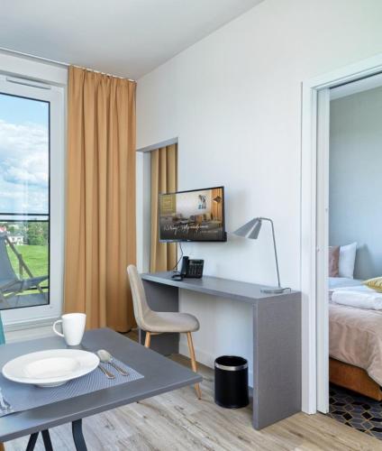a room with a desk and a bed and a table at Arche Hotel Poloneza in Warsaw